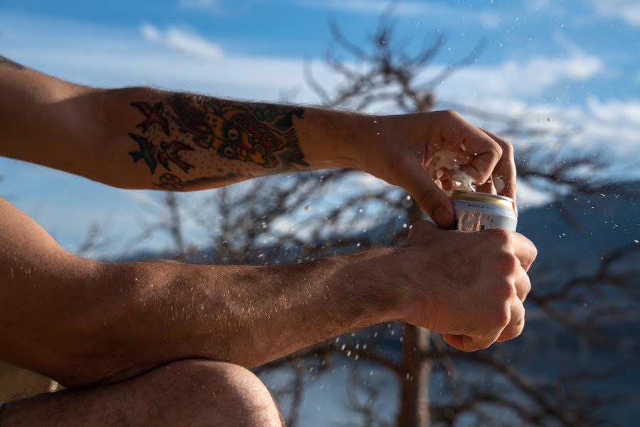 Dylan Medina, a Colorado State University chemistry major, opens a beer at the Horsetooth Reservoir April 2. (Photo illustration by Grayson Reed | The Collegian)