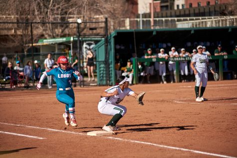 Colorado State infielder Danielle Serna (21) prepares to catch a pass to get New Mexico infielder Ashley Archuleta (7) out at first base April 8, 2022.