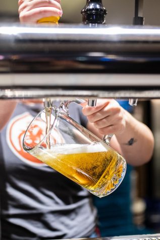 Claire Taagen of the Ram Skeller pours a beer April 8.