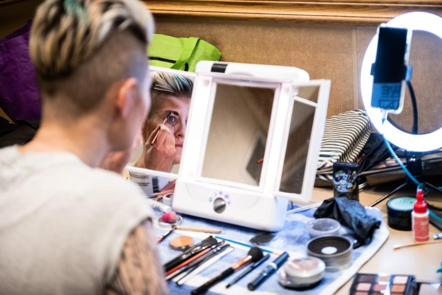 Drag King MaveRick applies their makeup backstage before the show