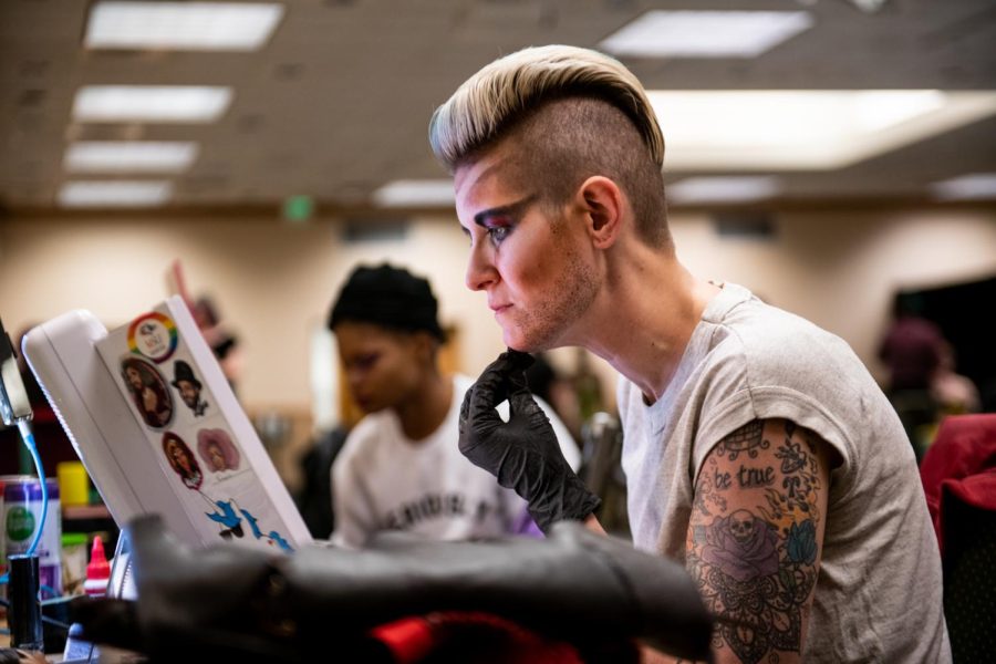 Drag King MaveRick applies their makeup backstage before the show