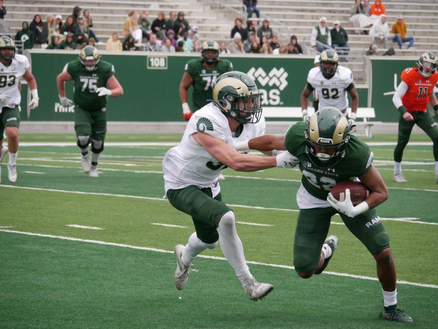 Colorado State wide receiver Dante Wright (22) stiff arms defensive back Liam Huber (32) at the Green and Gold game, April 23.