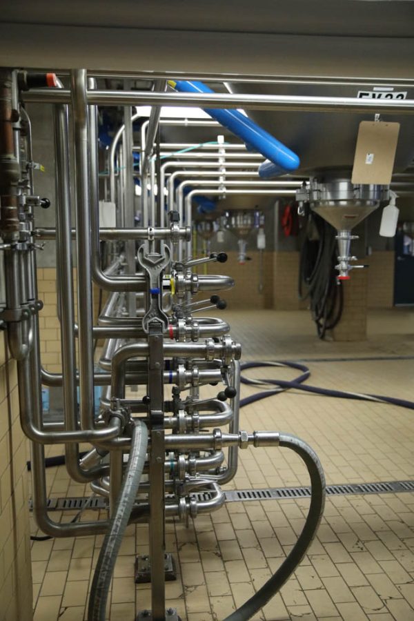 Various piping and hoses run throughout the room located underneath Odell Brewing Companys brewhouse April 6.