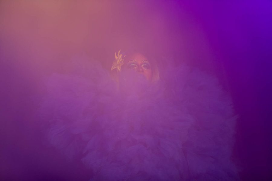 Coco Bardot beings a performance on stage during the Drag Show: Resurrection shrouded in fog and purple light April 16.