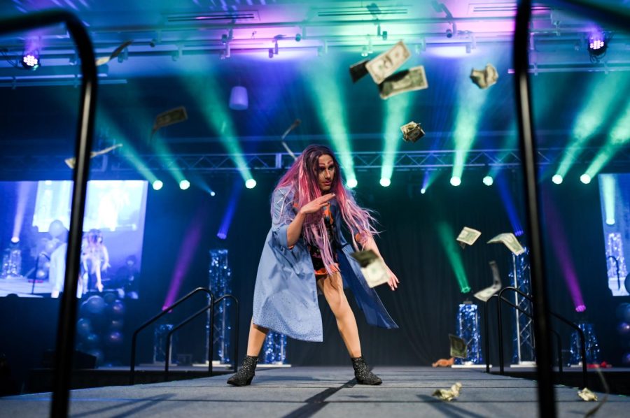 Mx Freudian Slip performs at the annual Colorado State University drag show as cash thrown onstage by crowd members rains down