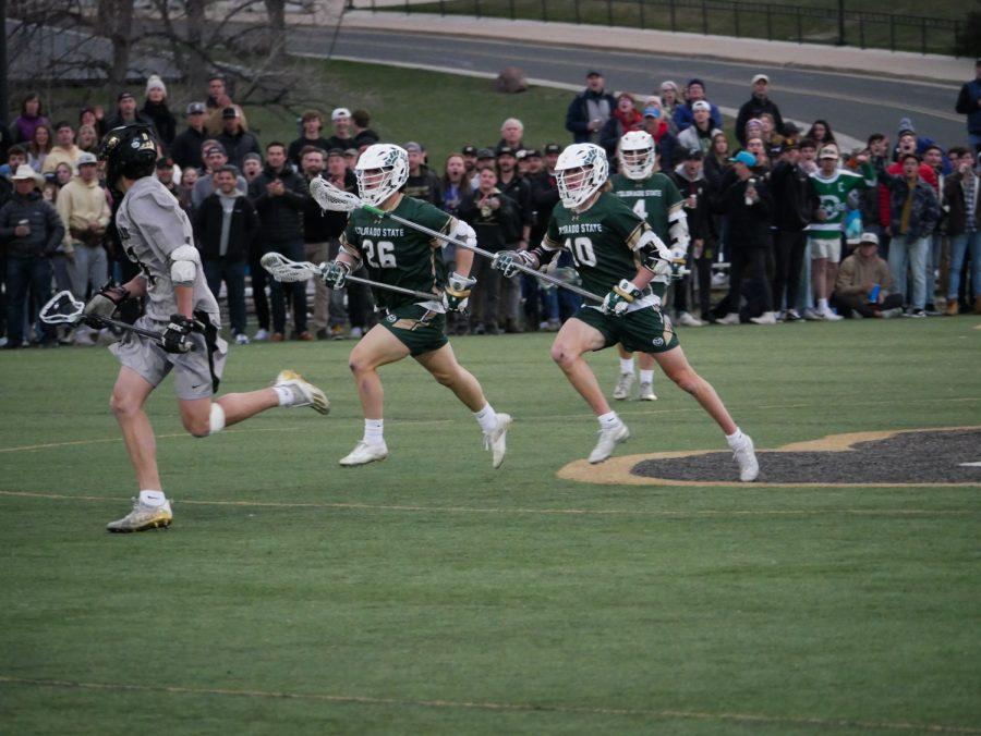 Colorado State defensemen Jordan Cutter (26) and Kale Kissell (10) pursue a University of Colorado player April 16.