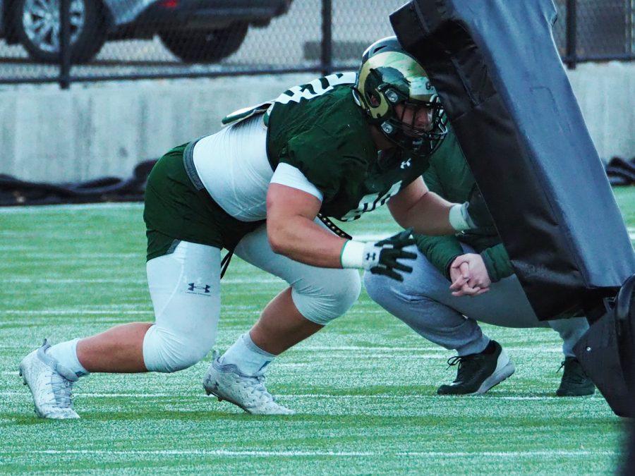 Sophomore defensive linemen Grady Kelly practices with a sled drill March 31, 2022.