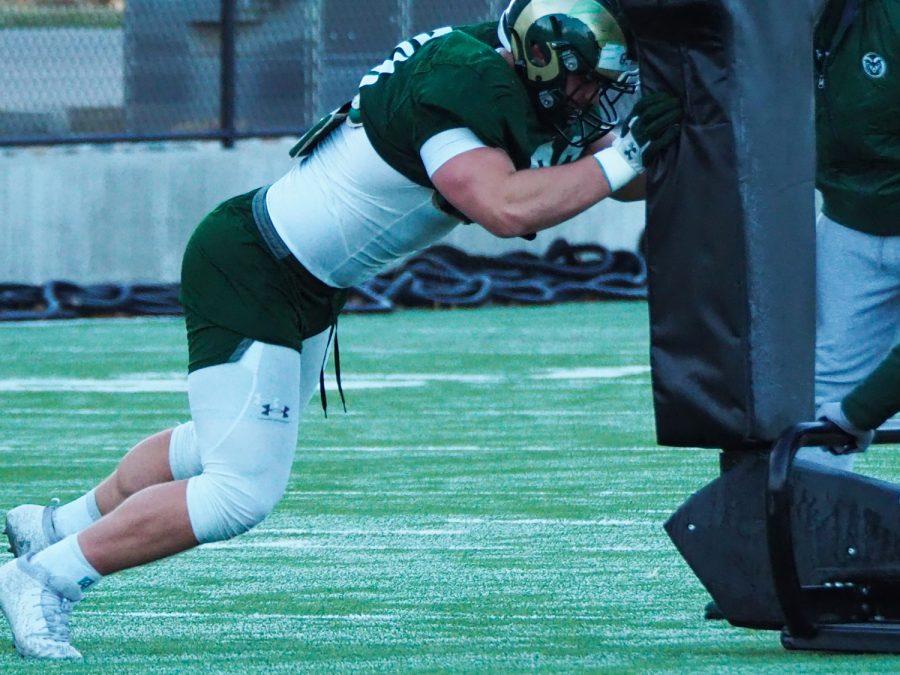 Sophomore defensive linemen Grady Kelly practices with a sled drill March 31, 2022.