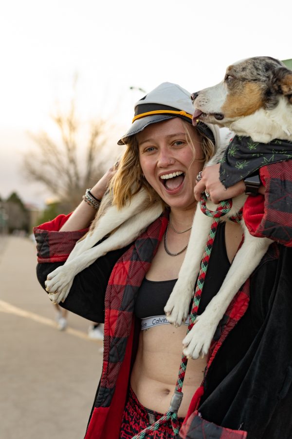 An undie run participant holds up their dog in front of the recenter