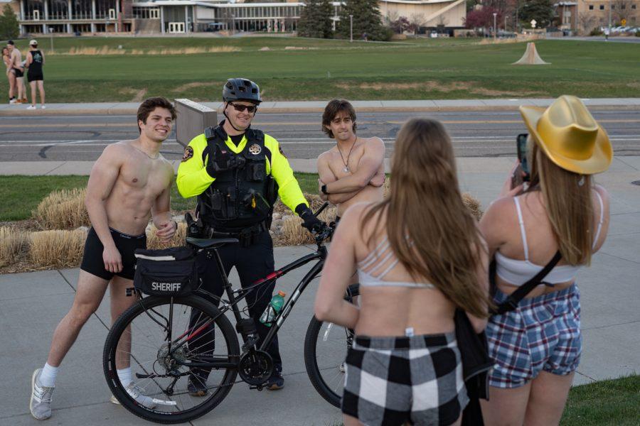 Undie Run participants take photos with a sheriff working at the event