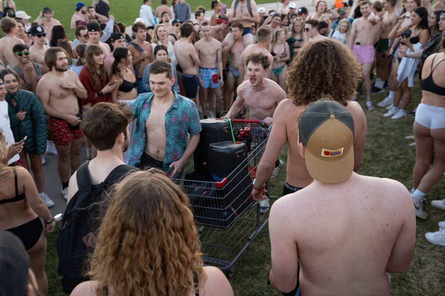 Undie Run participants push through crowds on the Logan Eastwood sits atop Todd Osobas shoulders to pose during their gathering on the intramural fields following the run with a shopping cart carrying a speaker on April 29.