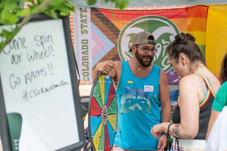 A representative from the Colorado State University Pride Resource Center talks to a festival-goer at the PRC tent