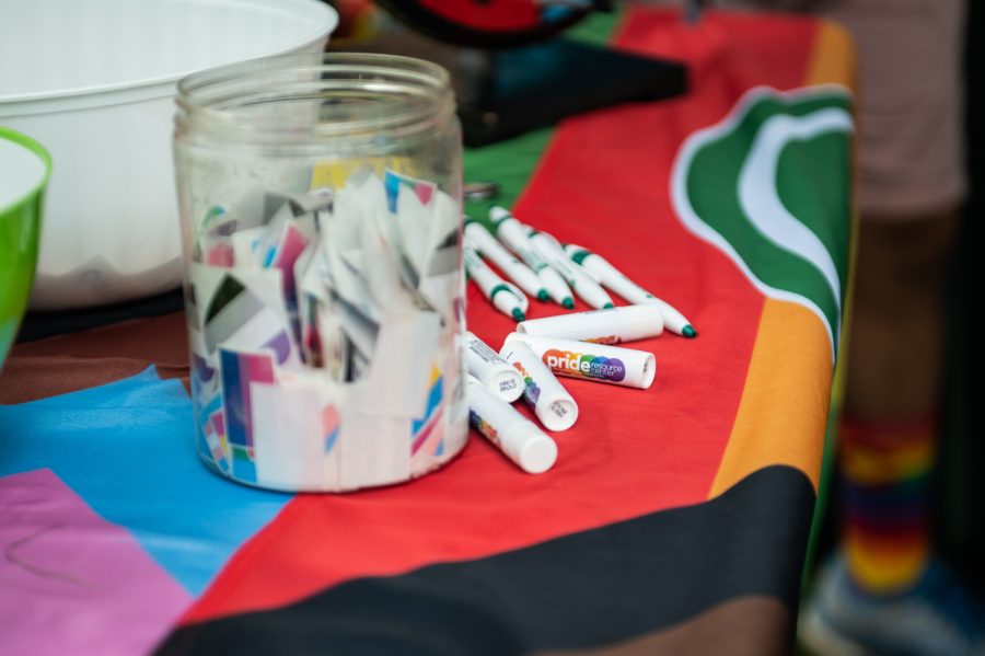 Free stickers and other merchandise sit at the Colorado State University Pride Resource Center tent at the 2022 NoCo Pride Festival