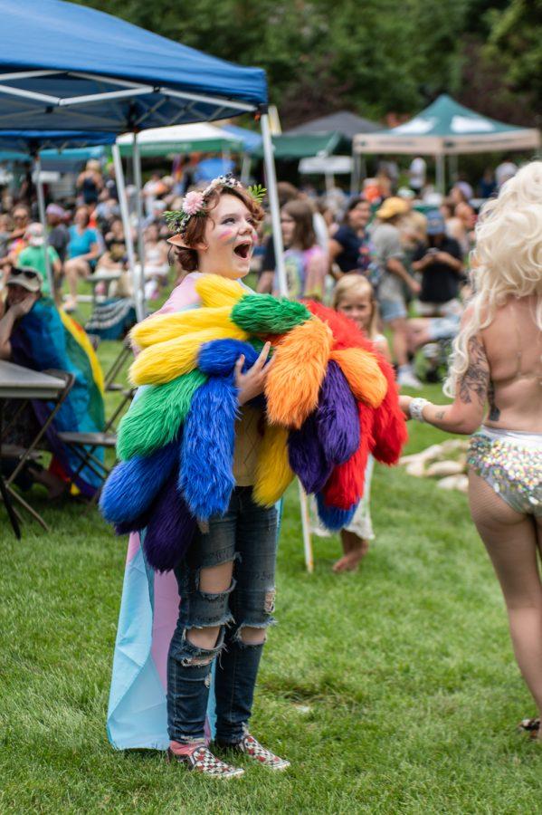 A young festival-goer reacts as a performer hands them part of their costume