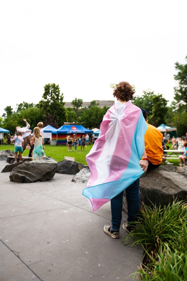 A young festival-goer watches a performer at the 2022 NoCo Pride Festival in Civic Center Park