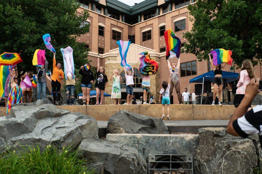 Young festival-goers wave Pride flags with a performer during the 2022 NoCo Pride Festival in Civic Center Park.