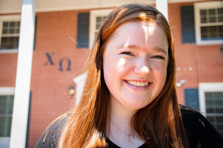 Mckenna Daly, President of Chi Omega in front of the sorority home