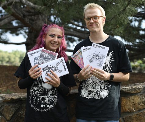 Maddy Erskine and Maxwell Hendrickson pose with all six editions of Scrapped Magazine Aug. 3 at City Park in Fort Collins. Erskine and Hendrickson are editors of the local music zine alongside Max Hogan. 