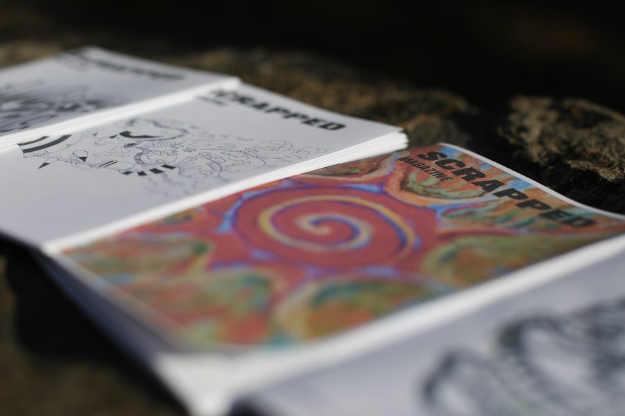 Copies of Scrapped Magazine lay out on a stone wall at City Park in Fort Collins Aug. 3, 2022. The zine features articles on local musicians alongside art, poetry and photography submissions.