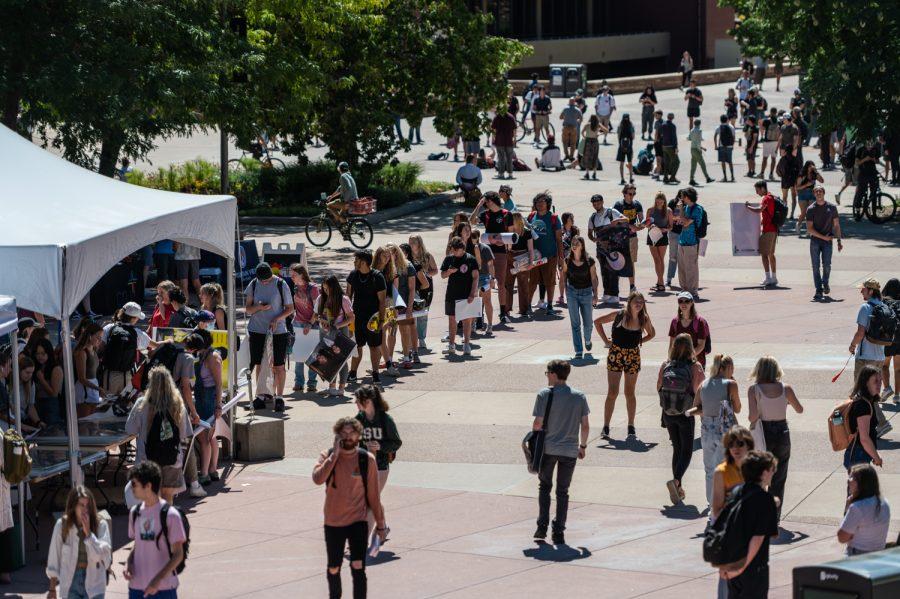 As students walk across the Colorado State University Plaza, a line of students waiting to buy posters from the Poster Invasion tent forms