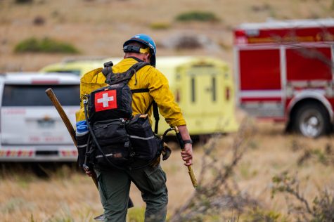 Wildland Firefighter brings gear back to the truck while fighting the County Road 21 Wildfire