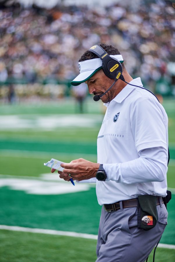 Colorado State University head coach Jay Norvell plans the team's next plays from the sideline during their season opener game against Middle Tennessee State University at Canvas Stadium