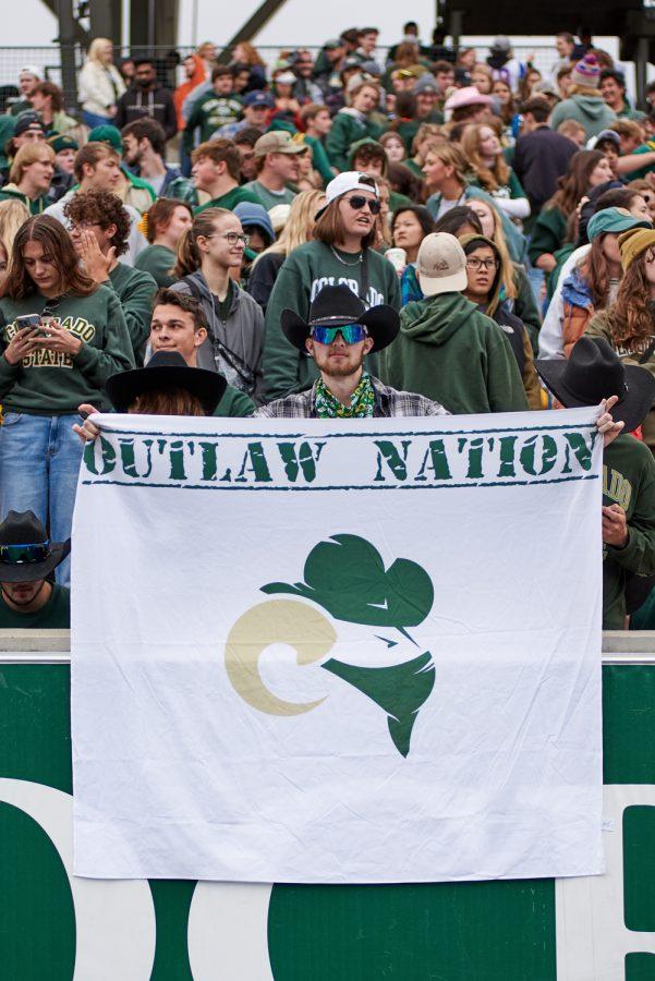 A Colorado State University fan holds an Outlaw Nation banner during the season opener game at Canvas Stadium