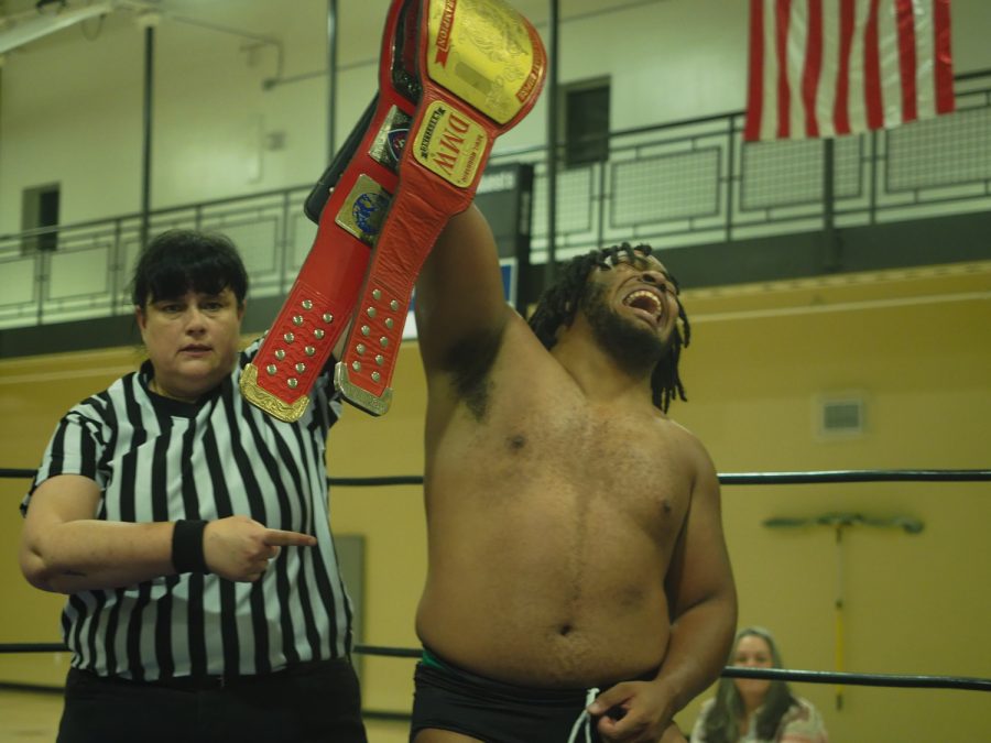 Alpha Coast Wrestling Unified Champion Alpha Zo holds up his heavyweight belt after winning against Gino Rivera at the Battleground Pro Wrestling fight night Sept. 3.