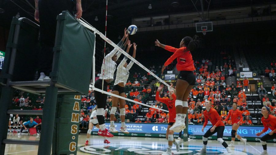 Colorado state middle blocker Kennedy Stanford (17) tips the ball over the net as University of Nevada Las Vegas middle blocker Dakota Quinlan (2) and rightside hitter Chloe Thomas (5) jump up to block Sept. 22. The Rams, who were wearing their orange out uniforms as a throwback to when they were the Colorado A&M Aggies, won 3-0 against the visiting UNLV Rebels. Stanford led the team with 11 kills.