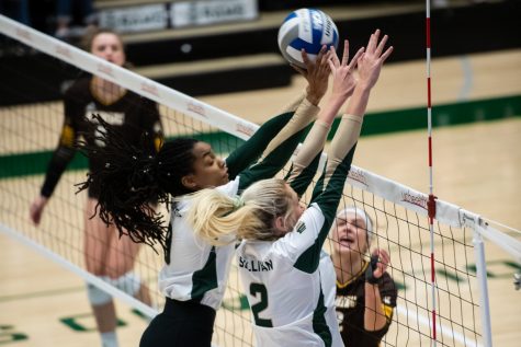 Colorado State middle blocker Naeemah Weathers (9) and outside hitter Annie Sullivan (2) block a hit from the University of Wyoming Sept. 20.
