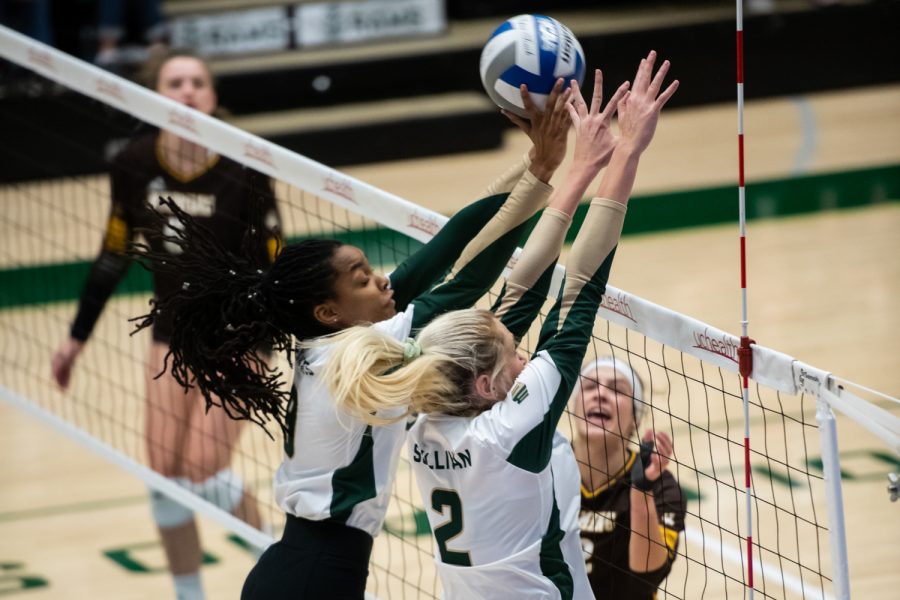 Colorado State middle blocker Naeemah Weathers (9) and outside hitter Annie Sullivan (2) block a hit from the University of Wyoming Sept. 20, 2022.