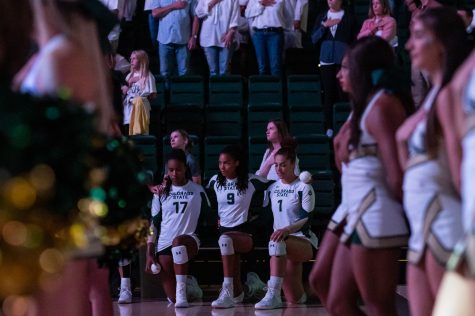 Outside hitter Kennedy Stanford (17), middle blocker Naeemah Weathers (9) and middle blocker Malaya Jones (1) kneel during the National Anthem before taking the court against the University of Colorado