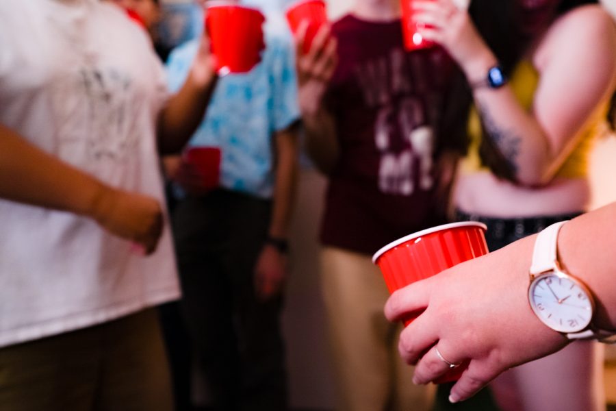Partygoers hold red Solo cups