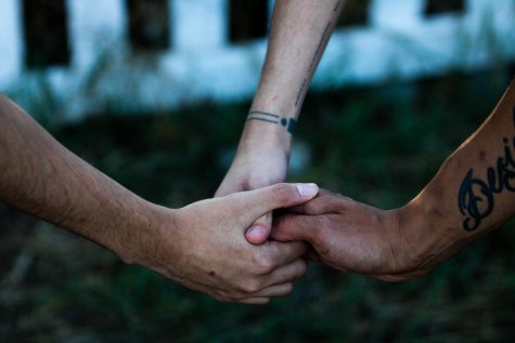 Three people hold hands