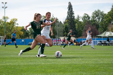 Colorado State University forward Caroline Lucas (27) races up the field with Utah State University defender Talia Winder (15) trailing next to her during the home game