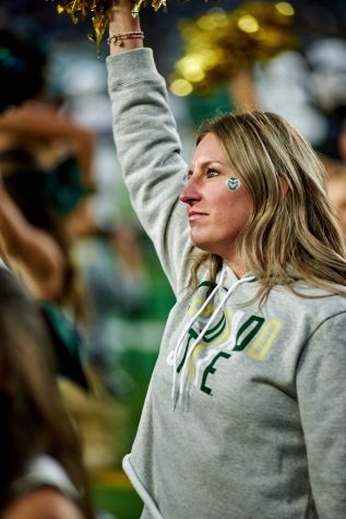 Cheerleader alumni return to the field to cheer on during the homecoming game