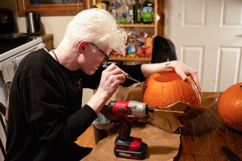 Miles Buchan, a Collegian cannabis reporter, cuts a hole for a mouthpiece into a pumpkin that became a bong