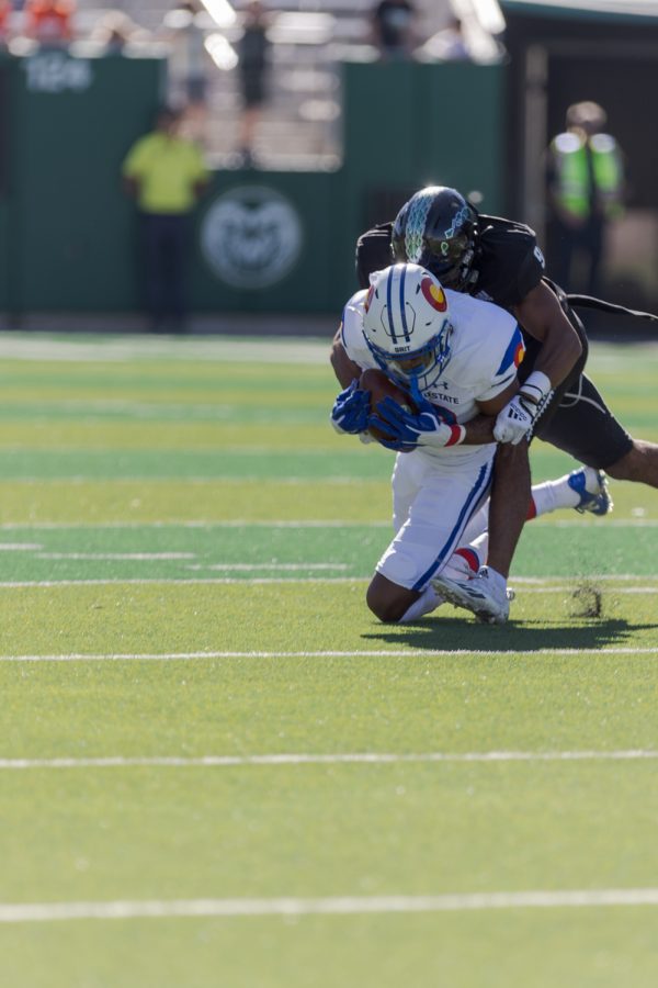 Colorado State University Wide Receiver Louis Brown is tackled while running the ball