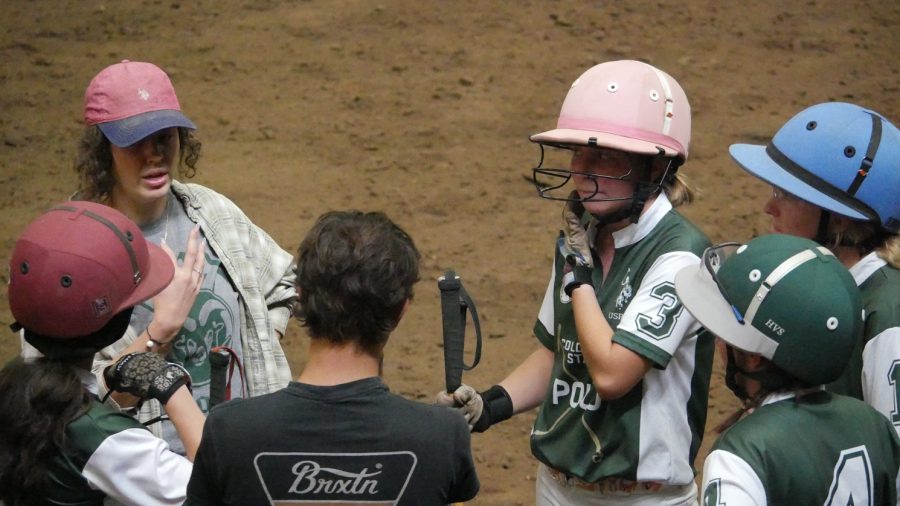 Members of the Colorado State University polo team huddle up with assistant coach Amelia Haddad between chukkers of their first game of the season against California Polytechnic State University