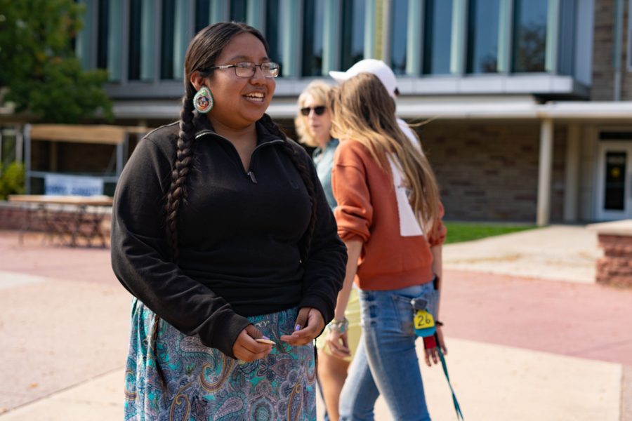 Ashton Barbone hands out Native American Cultural Center stickers to students passing by on the Plaza