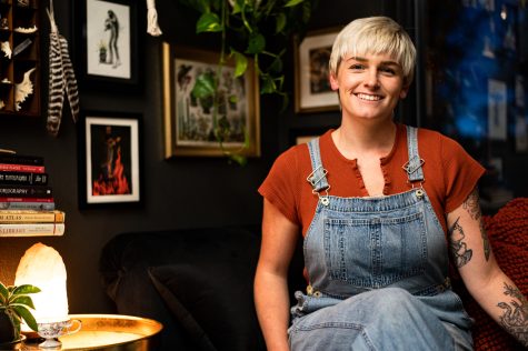 Madi Studer sits on the couch in one of the artist studios at Witch of The West Tattoo