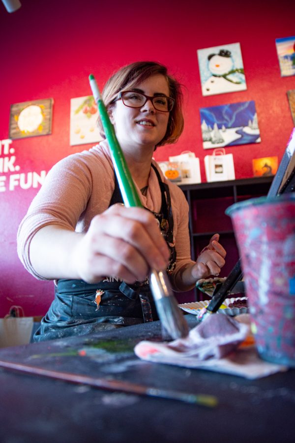 Morgan Lindquist, studio manager and artist, paints a picture of the galaxy with ultraviolet acrylic paint