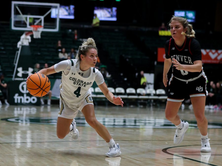 McKenna Hofschild (4), Colorado State University guard, dances around University of Denver guard Emma Smith (0) at Moby Arena Dec. 6, 2022. Hofschild recorded a double-double and surpassed 1,000 career points in the Rams 85-54 win Tuesday night.