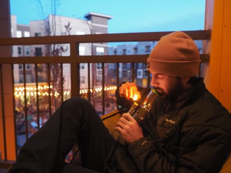 Colorado State senior Will Davis lights up his bong on the balcony of his apartment in Fort Collins Nov 3. Its important to layer up before going outside to smoke.