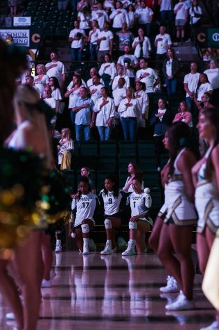 Colorado State University outside hitter Kennedy Stanford (17), middle blocker Naeemah Weathers (9) and middle blocker Malaya Jones (1) kneel during the national anthem before taking the court against the University of Colorado Boulder