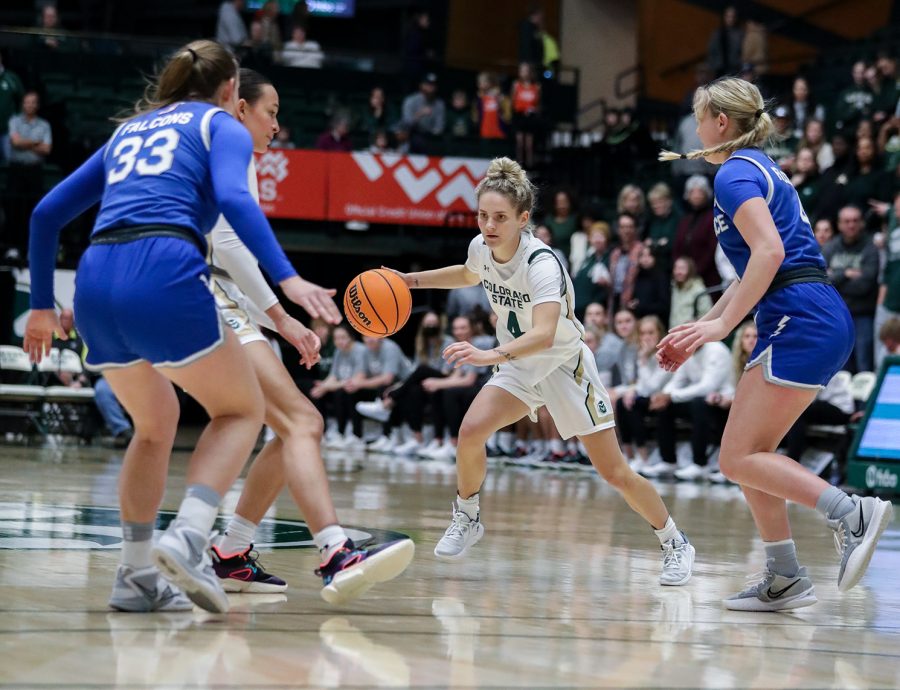 Colorado State University guard McKenna Hofschild (4) dribbles through United States Air Force Academy defenders thanks to a screen set by forward Kendyll Kinzer (0) at Moby Arena Feb. 18, 2023. Hofschild led the Rams to a 67-64 win with 25 points and eight assists.
