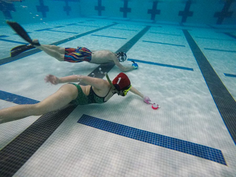 Underwater hockey players keeps for the puck away from another player at Edora Pool Ice Center (EPIC) recreation center in Fort Collins, Colorado Feb. 7