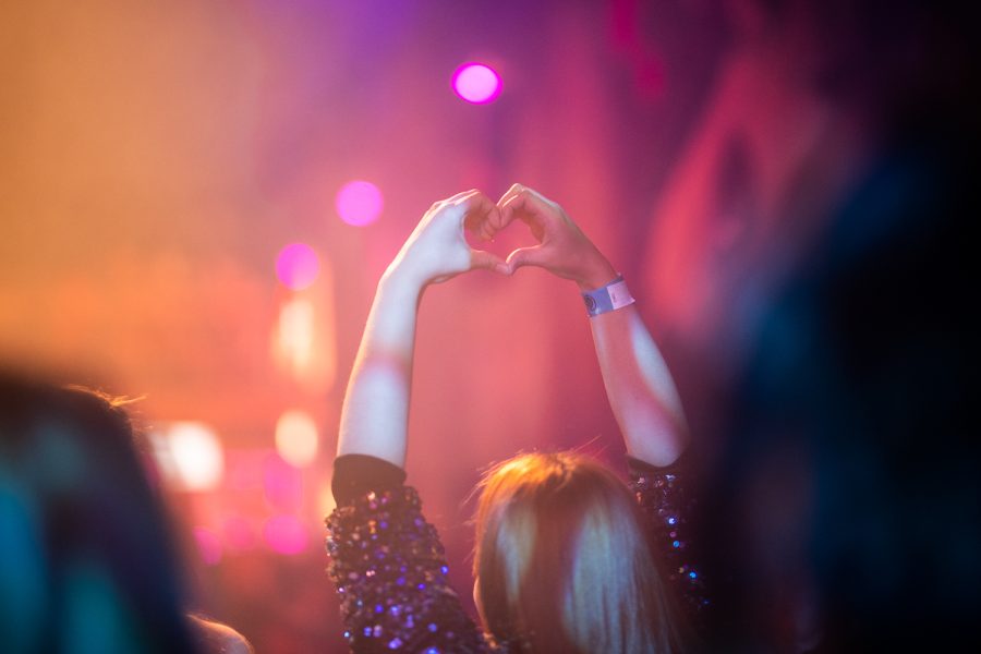 A Taylor Swift fan holds their hands in a heart shape while dancing on stage at Taylor Fest Feb. 11. Early in Swift’s career, she was known for making this hand shape to fans.
