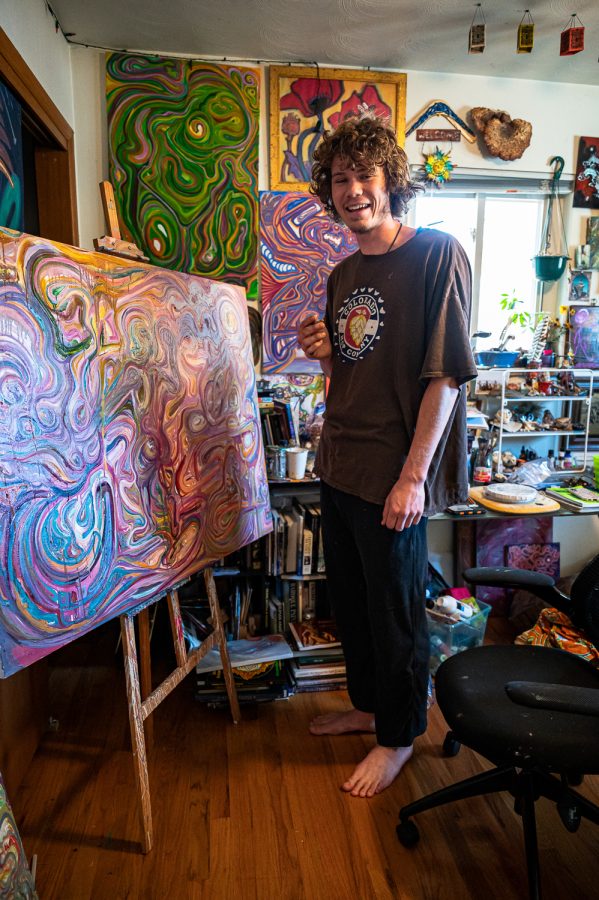 Trevor Stewart works on a painting titled “Alchemical So(u)n” in his Fort Collins home