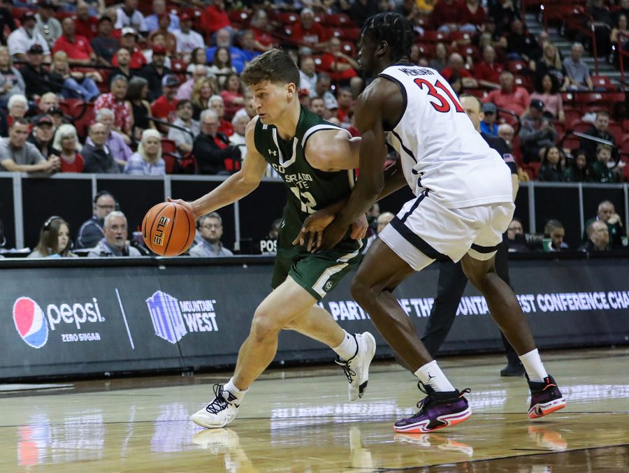 Colorado State University forward Patrick Cartier (12) dribbles around San Diego State University forward Nathan Mensah (31) in the Thomas & Mack Center in Las Vegas March 9, 2023. The Rams lost 64-61 in the quarterfinals of the 2023 Mountain West Basketball Championships.